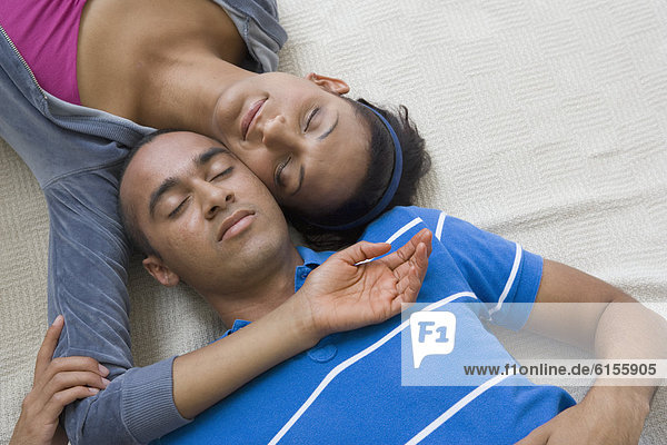 Young couple laying with heads touching