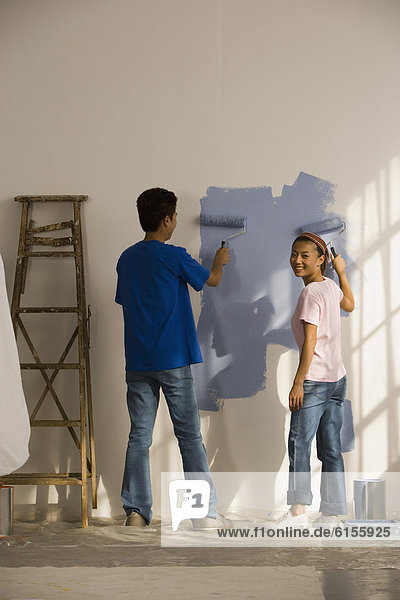Asian couple painting interior house