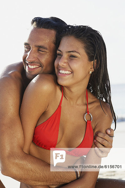 South American couple hugging at beach