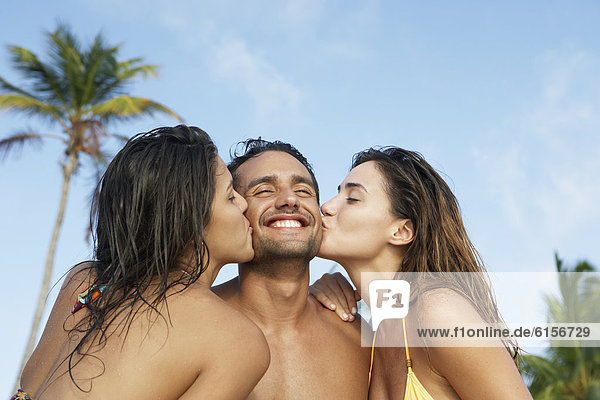 South American women kissing man on both cheeks