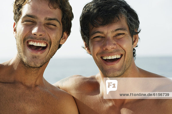 South American men laughing at beach