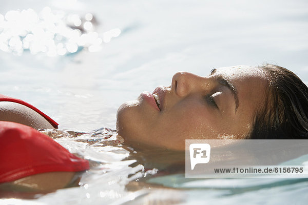 South American woman floating in water