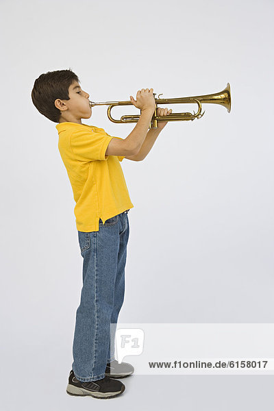 Middle Eastern boy playing trumpet