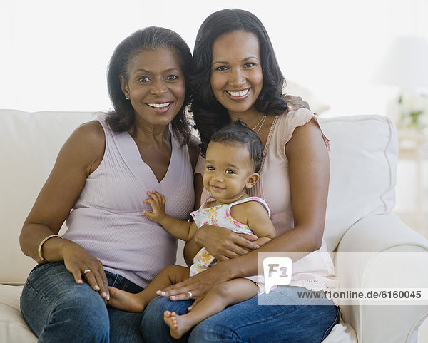 African American grandmother  mother and baby on sofa