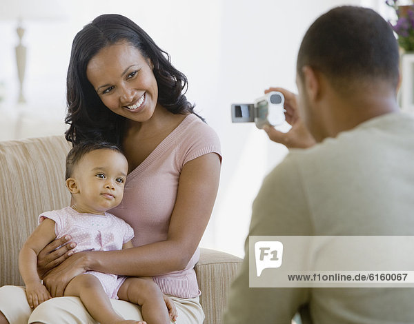 African American father taking photograph of family