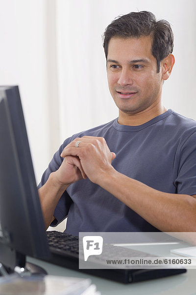 Hispanic man looking at computer