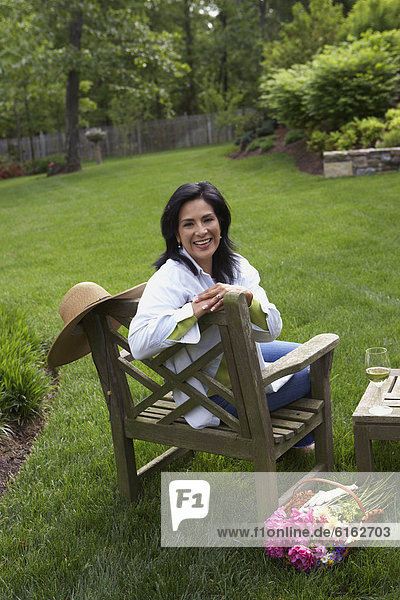 Hispanic woman sitting in backyard