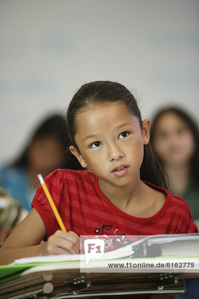 Asian girl at desk in classroom