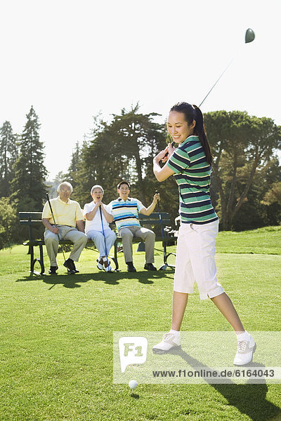 Asian woman playing golf