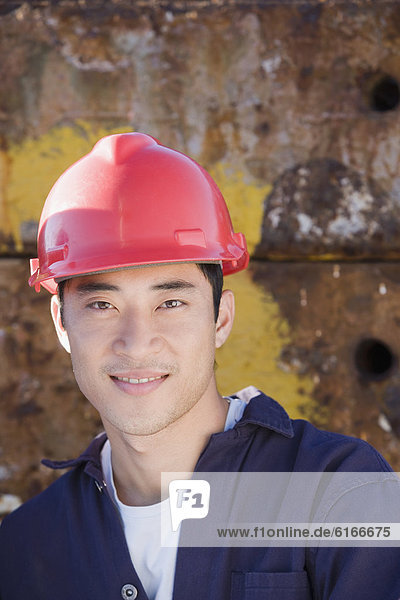 Asian male construction worker wearing hardhat