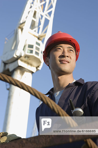 Asian male construction worker wearing hardhat