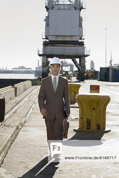 Asian businessman walking on commercial pier