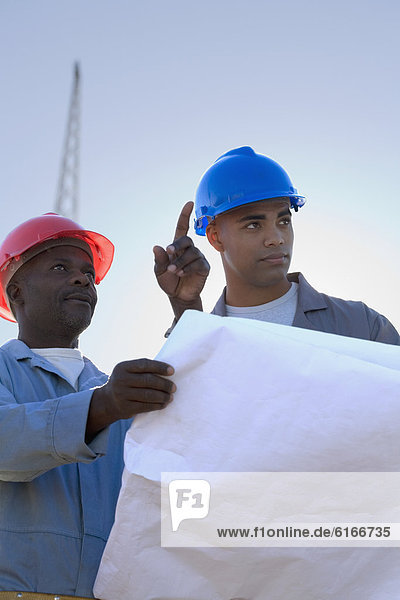 African American construction workers with blueprints
