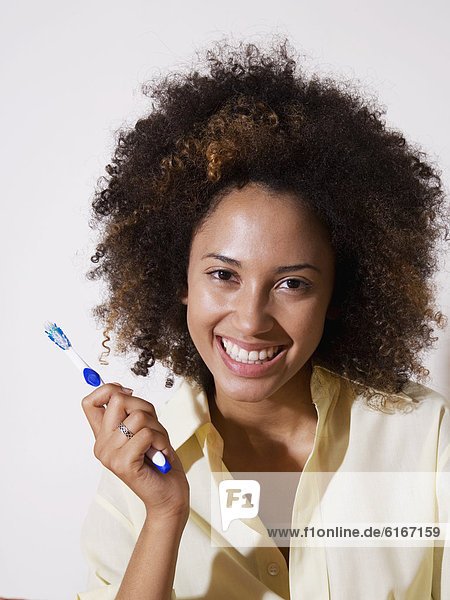 African woman holding toothbrush