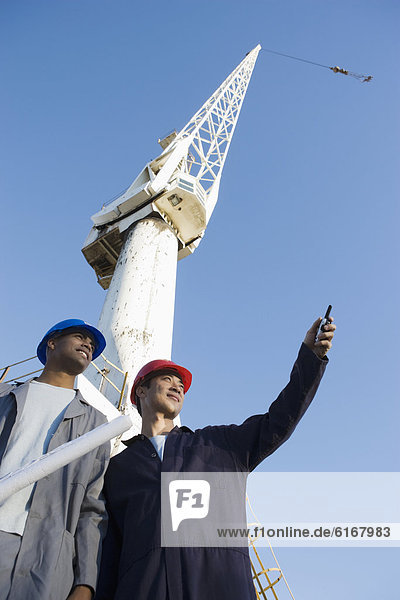 Multi-ethnic male construction workers under crane