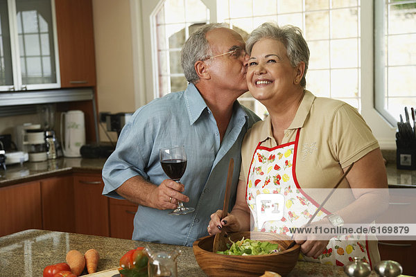 Senior Hispanic man kissing wife
