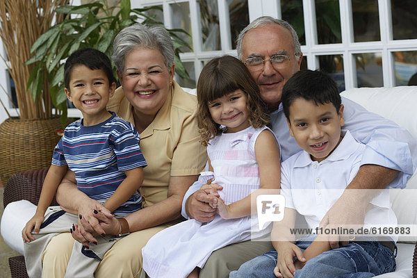 Hispanic grandparents hugging grandchildren