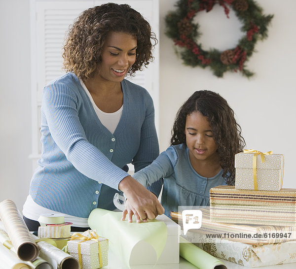 African mother and daughter wrapping gifts