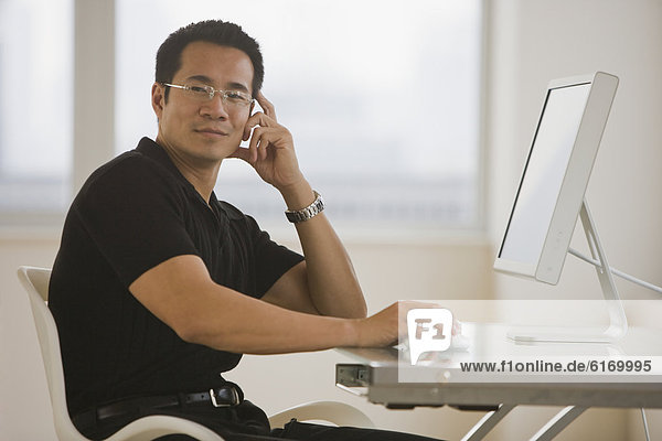 Asian businessman sitting at desk