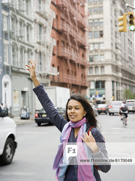 Mixed Race woman hailing taxi cab