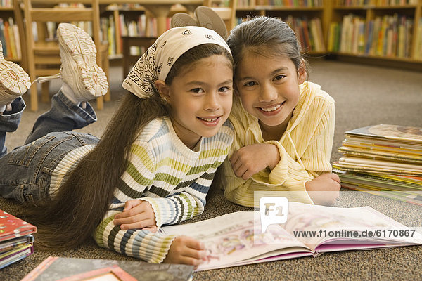 Pacific Islander girls reading in library