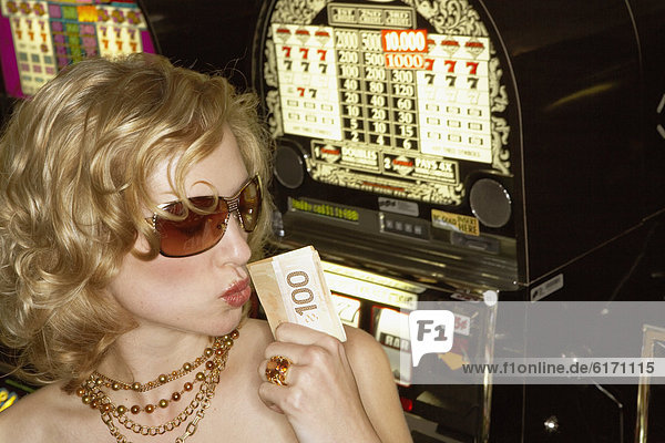 Young woman holding her winnings at the casino