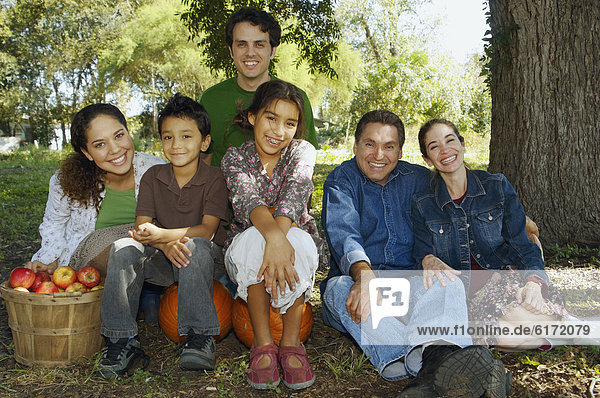 Multi-ethnic family sitting under tree