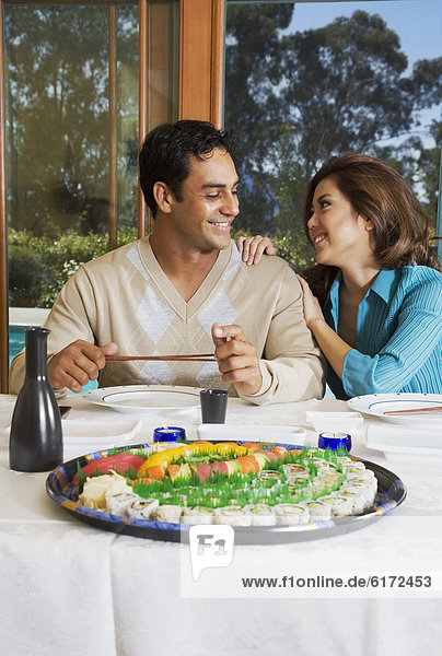 Multi-ethnic couple eating sushi