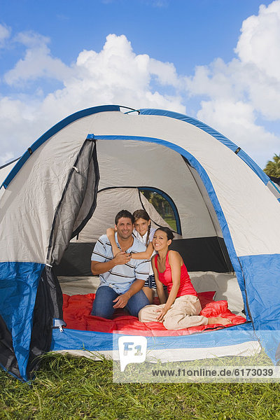 Hispanic family sitting in tent
