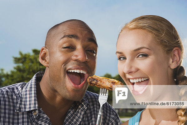 Multi-ethnic couple eating from same fork
