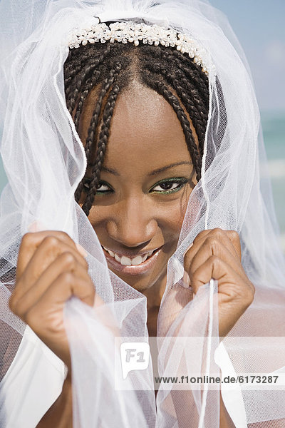 African bride pulling veil forward