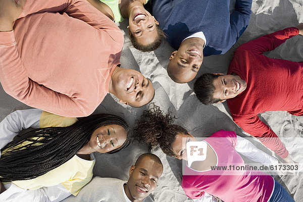 Multi-ethnic friends laying in circle