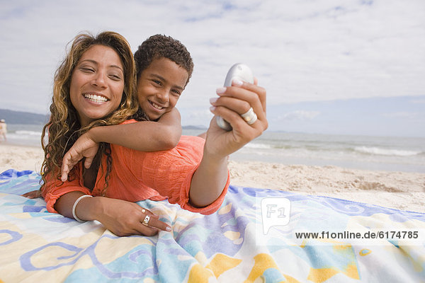 Mother and son taking self portrait on the beach