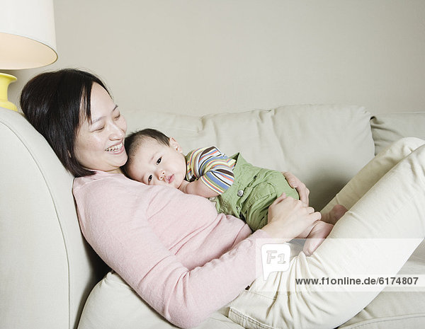 Asian mother and baby on the sofa