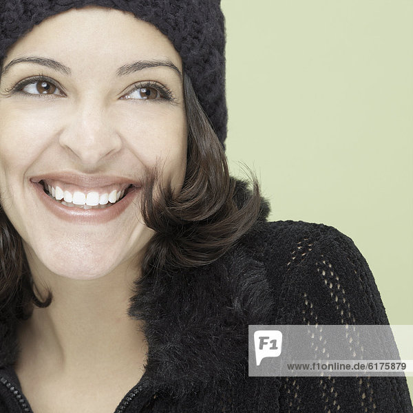 Studio shot of young Hispanic woman smiling