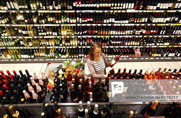 Frau beim Einkaufen in Getränkeabteilung  Sekt  Champagner  Schaumweine  Regal  Selbstbedienung  Deutschland  Europa