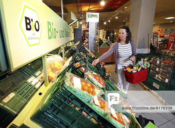 Frau kauft in der Obst- und Gemüseabteilung ein  Bioprodukte  Selbstbedienung  Lebensmittelabteilung  Supermarkt  Deutschland  Europa