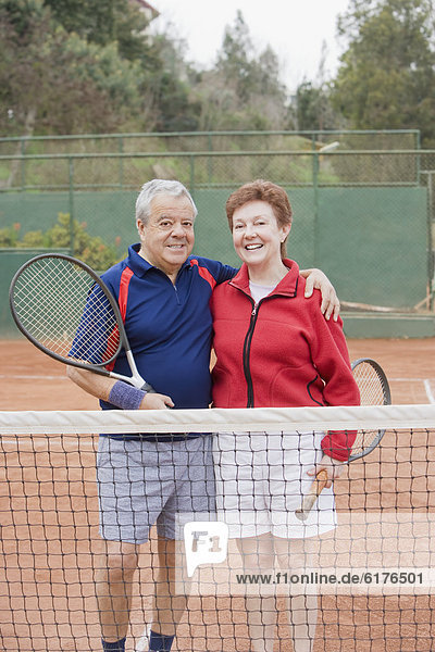 Senior Hispanic couple playing tennis