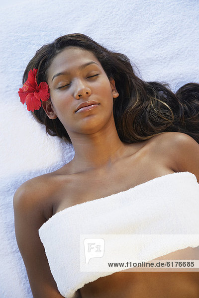 Hispanic woman laying on spa table