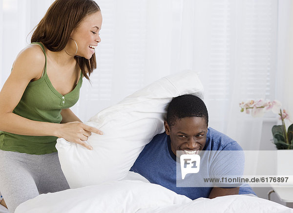 African couple having pillow fight