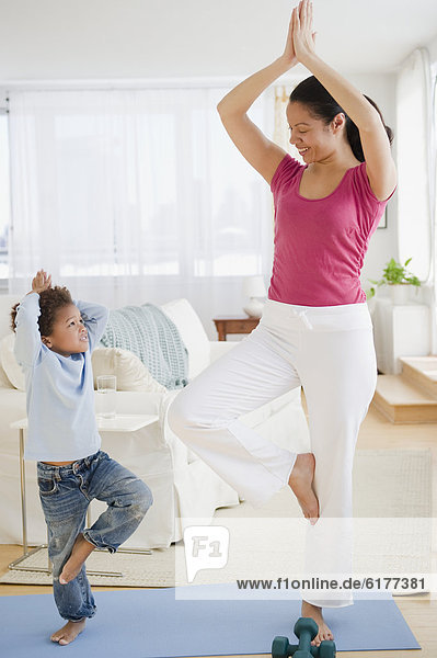 Mixed race mother and son practicing yoga
