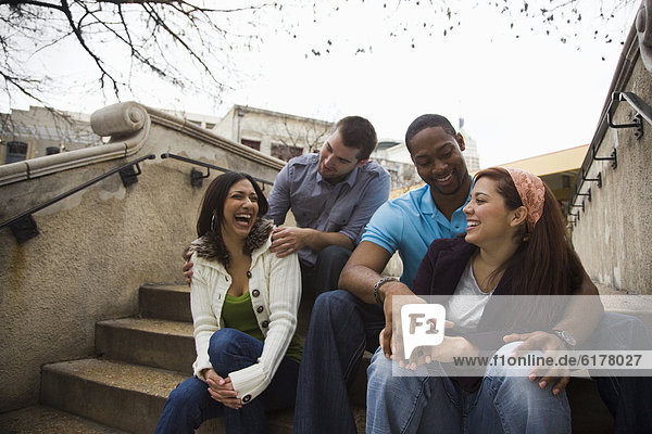 Laughing couples sitting on steps together