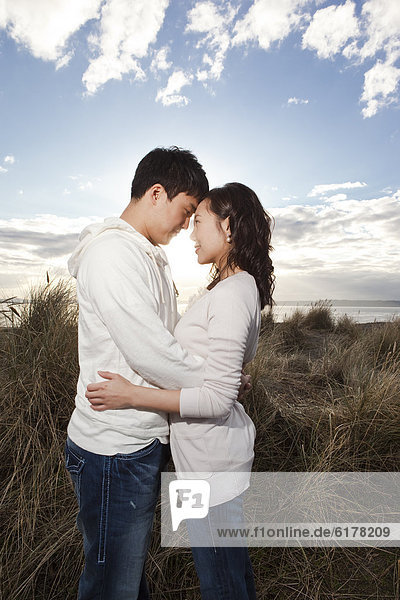 Korean couple hugging on beach