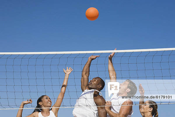 Multi-ethnic friends playing volleyball