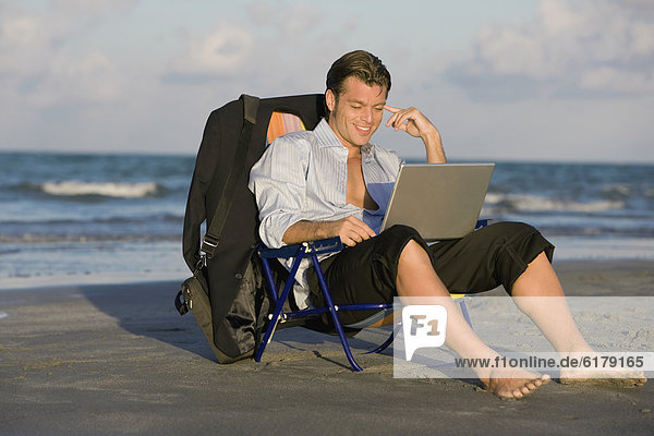 Hispanic businessman looking at laptop