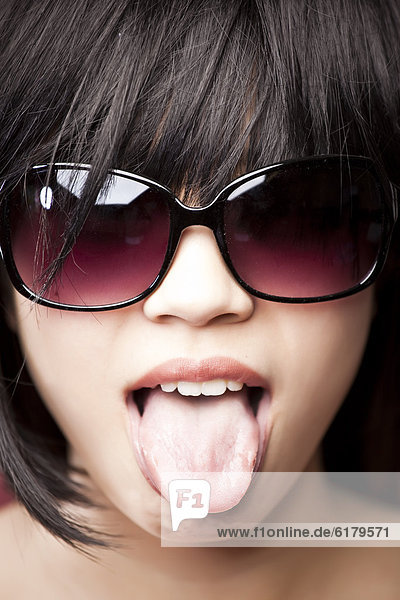 Frau  chinesisch  Kleidung  Zunge herausstrecken  Sonnenbrille