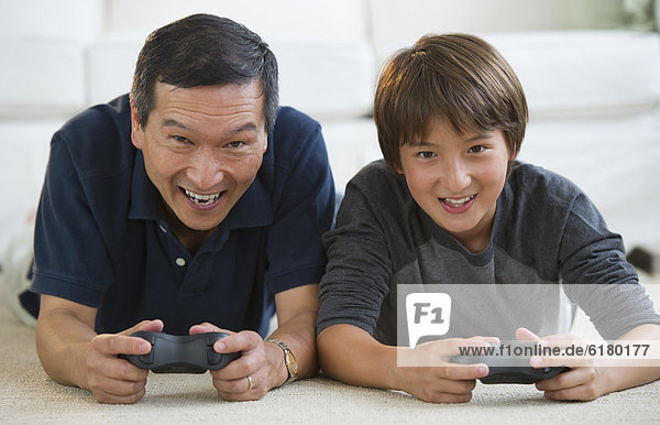 Father and son playing video game on living room floor