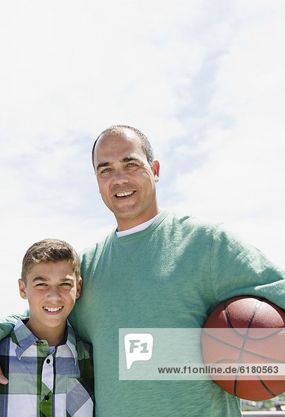 Hispanische Vater und Sohn mit basketball