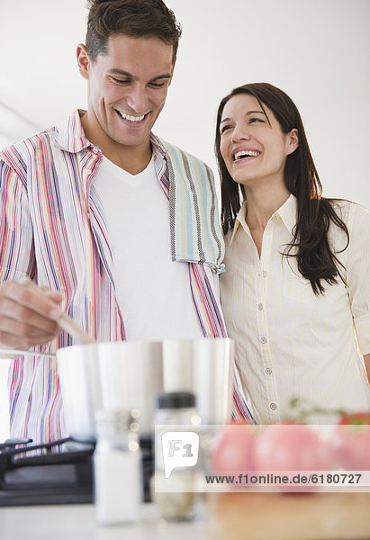 Smiling couple cooking dinner together