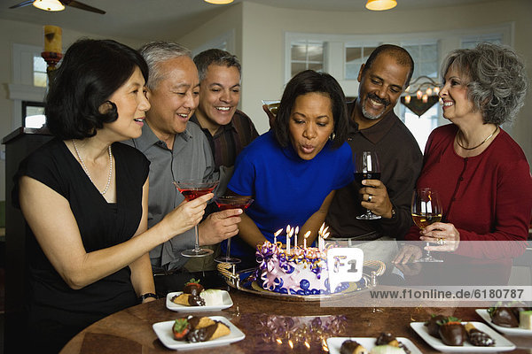 African woman celebrating birthday with multi-ethnic friends